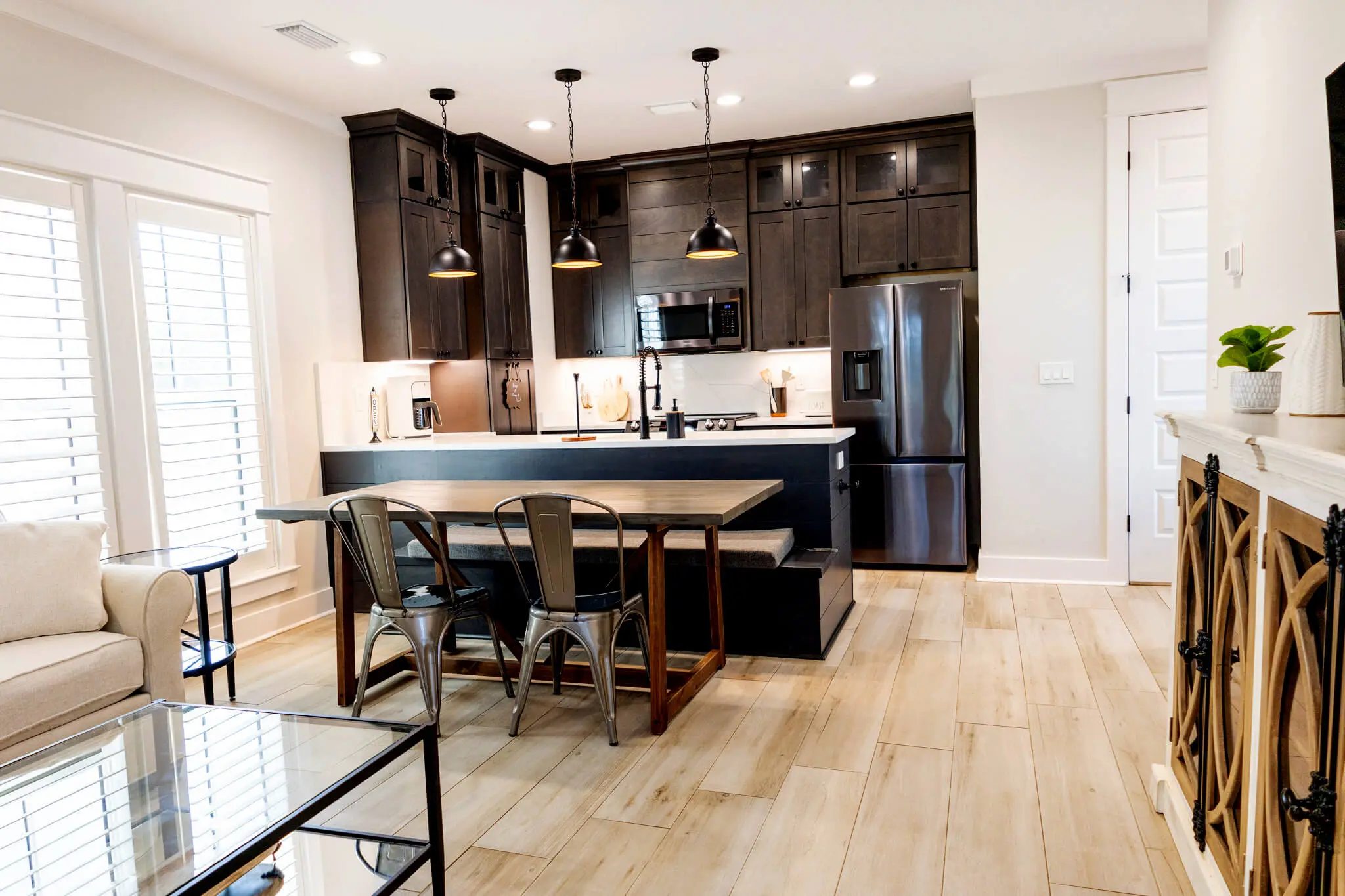 Modern coastal kitchen with dark cabinets, island seating, and natural light in Santa Rosa Beach, Florida