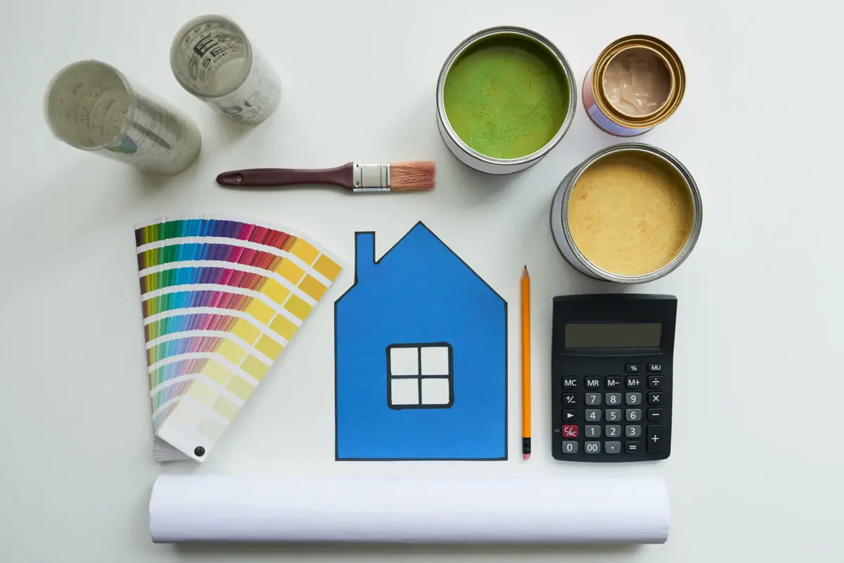 Painting supplies laid out with color swatches, paint cans, brush, calculator, and house graphic illustrating what to know before repainting your home